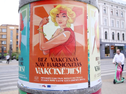 Vakcinācijas pret Covid-19 vides plakāti uz reklāmstaba. Foto: Paula Čurkste, LETA