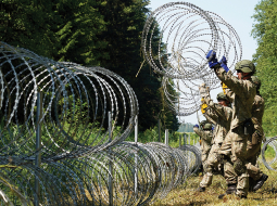 Lietuvas armijas karavīri izvieto dzeloņstieples uz robežas ar Baltkrieviju pie Druskininkiem.
Foto — Scanpix