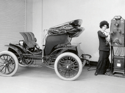 1906. gadā amerikāņu kompānijas Pope ražotais elektroauto tiek uzlādēts ar strāvas ģeneratoru, kas darbināms ar roku