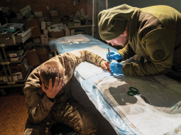 Militārais mediķis operē viegli ievainotu ukraiņu karavīru 17. janvārī Doneckas frontē.
Foto — Scanpix