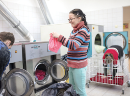 Darbnīcas apmeklētājiem jāiemācās viss, kas saistīts ar veļas mazgāšanu — šķirot, ieslēgt mašīnu, žāvēt, gludināt... Inga Miezone šīs prasmes jau apguvusi, nu sapņo iemācīties adīt zeķes.
Foto — Reinis Hofmanis