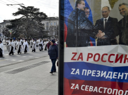 Krievijas preizticīgo baznīcas gājiens Krimā šogad janvārī Sevastopolē. Plakātā redzams Krievijas prezidents Putins, kurš spiež roku Maskavas ieceltajiem Krievijas okupēto reģionu vadītājiem Ukrainas austrumos. Foto - AP/Scanpix/LETA