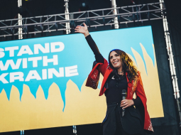 Dziedātāja Džamala pie Ukrainas atbalsta plakāta.