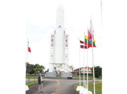 Roberts Purvinskis pie nesējraķetes Ariane 5 modeļa Kuru kosmodromā. Tur plīvo arī sarkanbaltsarkanais karogs, jo Latvija ir Eiropas Kosmosa aģentūras asociētā dalībvalsts.
Foto no personīgā arhīva
