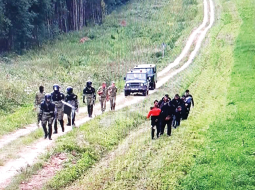 Baltkrievu robežsargi pavada migrantus uz Lietuvas robežu.
Foto — Lietuvas robežsardze