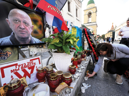 Jevgeņija Prigožina atbalstītāji noliek ziedus pie stihiski ierīkota piemiņas memoriāla Maskavas centrā.
Foto — Scanpix