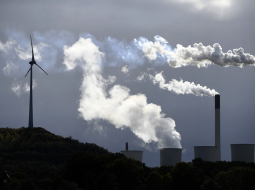 Dūmi no globālās energoapgādes uzņēmuma "Uniper" ogļu spēkstacijas līdzās vēja turbīnai Vācijas pilsētā Gelzenkirhenē 2019. gadā. Foto - INA FASSBENDER, AFP