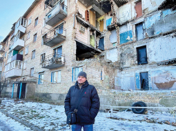 Serhijs Demčenko pie izpostītās mājas, kurā atrodas arī viņa dzīvoklis.
Foto no personīgā arhīva