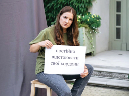 Marija Sinčaka karavīru sievām sarīkotajā fotosesijā ar plakātu Nemitīgi aizsargā savas robežas.
Publicitātes foto