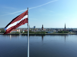 Latvijas karogs uz AB dambja un Rīgas panorāma. Foto - Kaspars Nordens, LETA