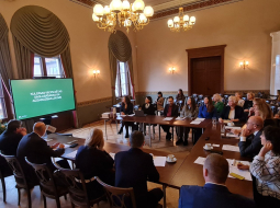 2025. gada 28. oktobra 14. Saeimas Valsts pārvaldes un pašvaldības komisijas sēde Kuldīgas jaunajā rātsnamā, aiz loga vecais rātsnams un vecākā Kurzemes koka ēka. Kristīnes Jarinovskas foto.