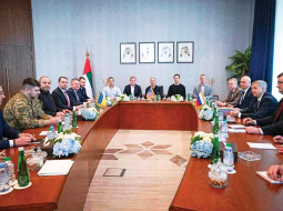 Ukrainas (pa kreisi) un Krievijas (pa labi) delegāciju sarunas Abū Dabī 24. janvārī. Vidū vidutāji no ASV.