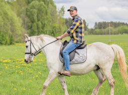 Dainis baltā rikšotāja Hektora mugurā. Foto — Ieva Babre
