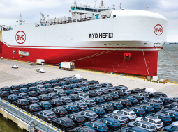 BYD elektroauto pirms iekraušanas kravas kuģī ostā pie Šanhajas.
