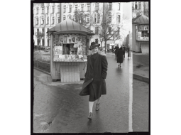 Sieviete pie avīžu kioska Marijas ielā Rīgā. 1935.—1939. gads. Foto — Alberts Neilands. Latvijas Nacionālā arhīva krājums